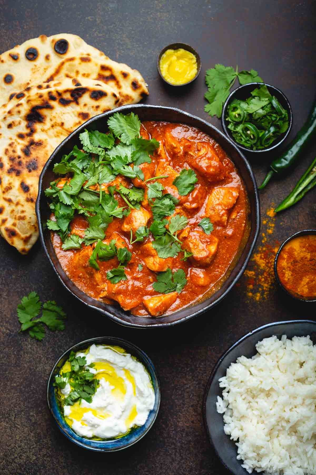 A vibrant bowl of Chicken Tikka Masala with naan bread