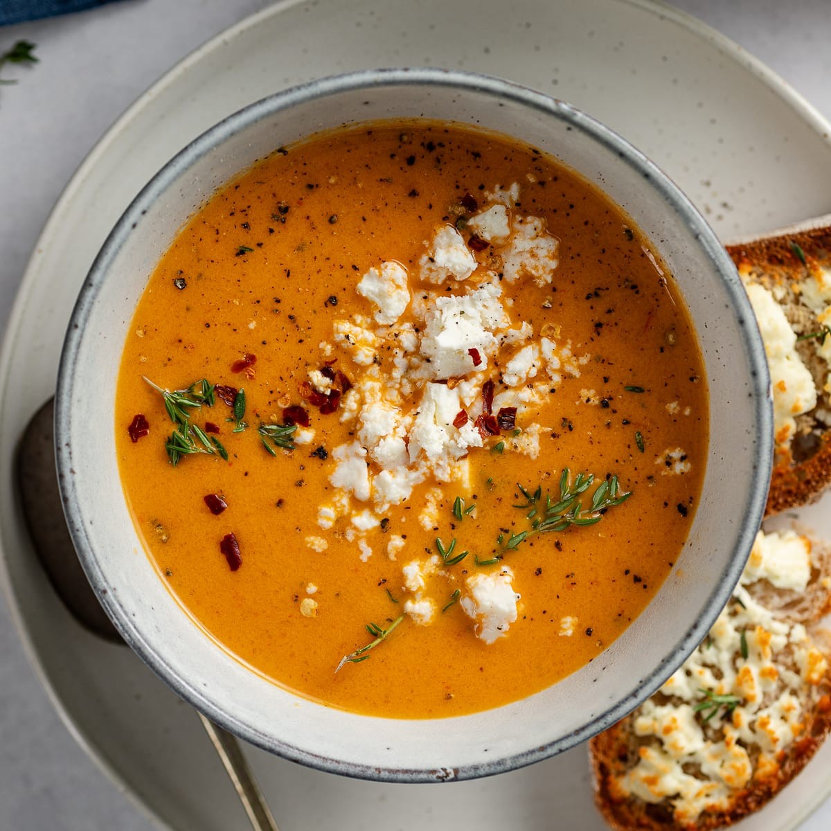 bowl of roasted red pepper and pumpkin soup with feta