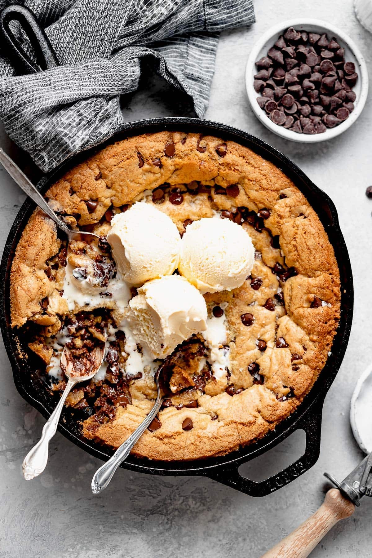 Decadent triple chocolate cookie skillet with melted chocolate chips and a scoop of vanilla ice cream