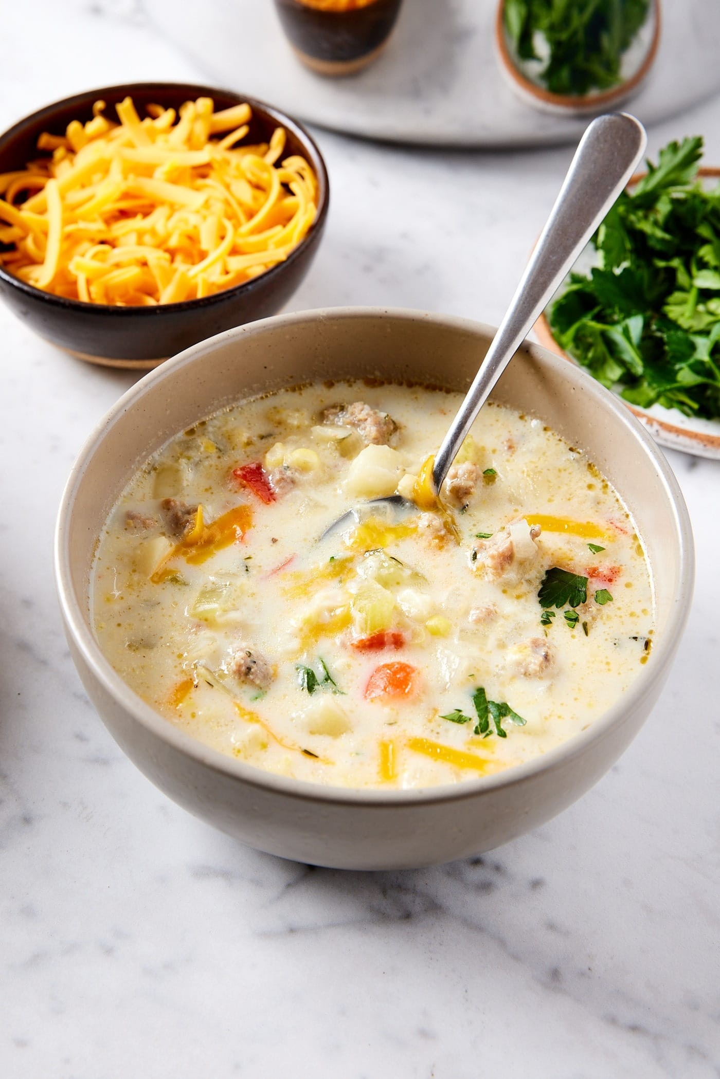 A bowl of creamy corn chowder garnished with fresh herbs