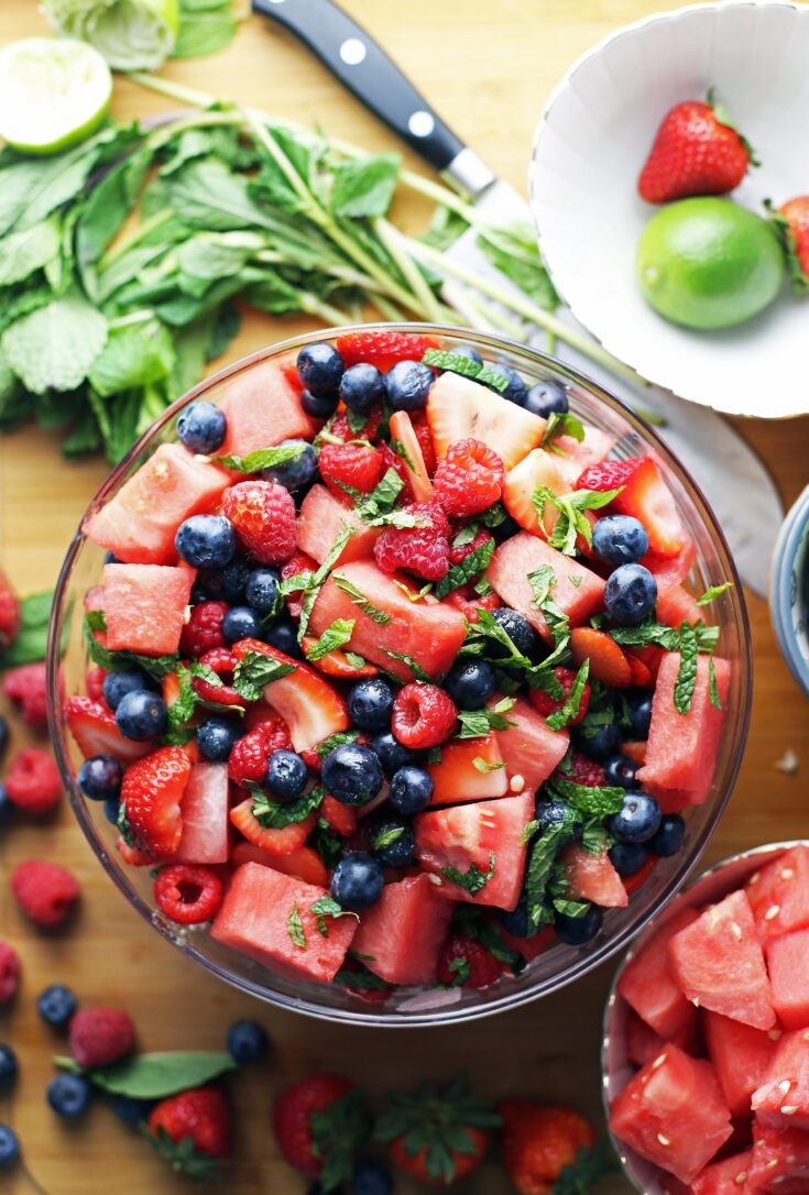 A vibrant summer salad with chunks of watermelon and blackberries, drizzled with a lemon-thyme dressing