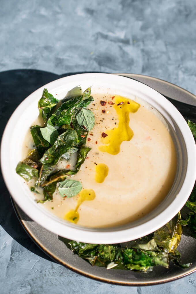 Bowl of vegan kohlrabi soup garnished with fresh dill
