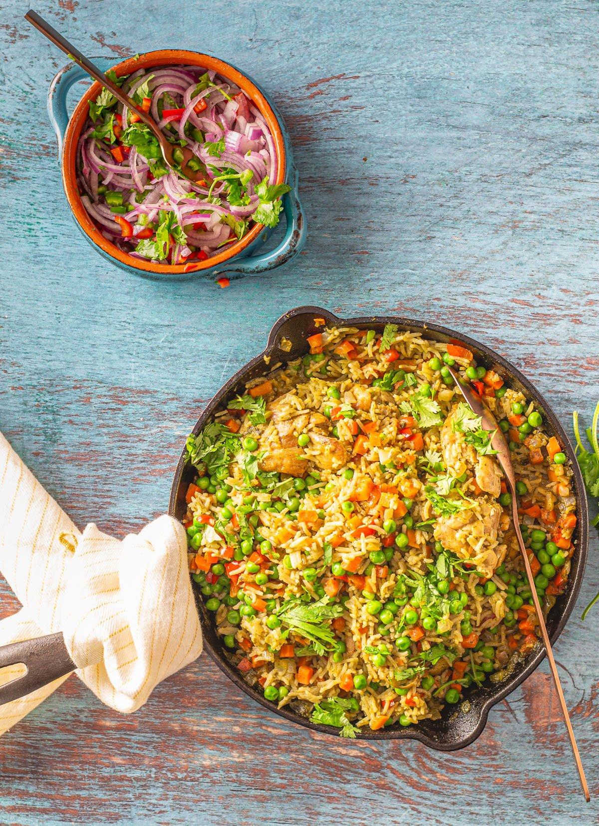 Peruvian-style Jollof rice with aji amarillo peppers in a rustic bowl, garnished with cilantro