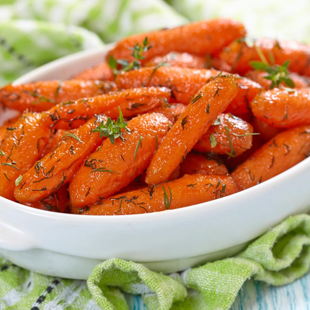 Close-up of roasted carrots glistening with orange glaze and cumin seeds