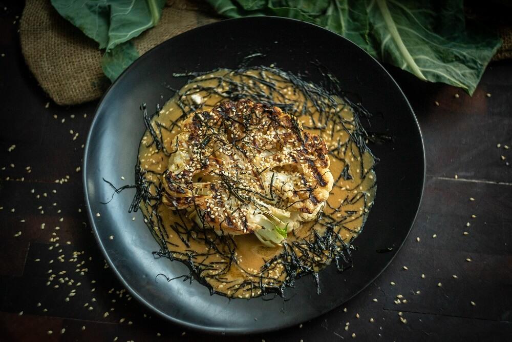 miso-glazed cauliflower steaks with sesame seeds on a plate