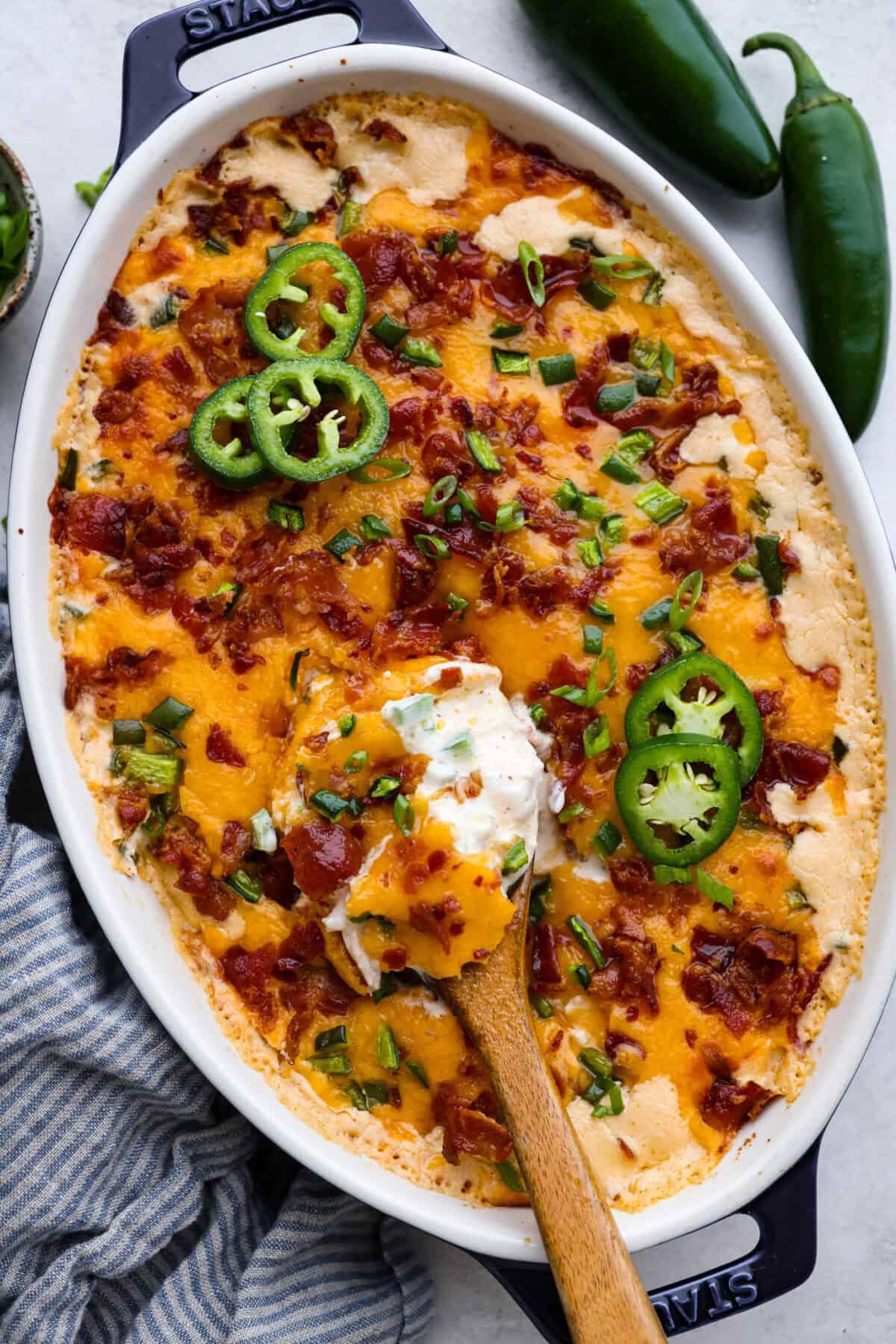 overhead shot of assembling jalapeno popper casserole in a baking dish
