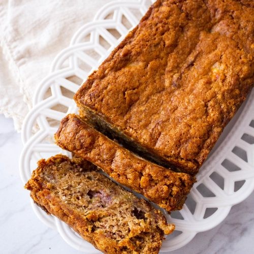 Close up shot of a warm, sliced caramel banana bread loaf with gooey caramel drizzle